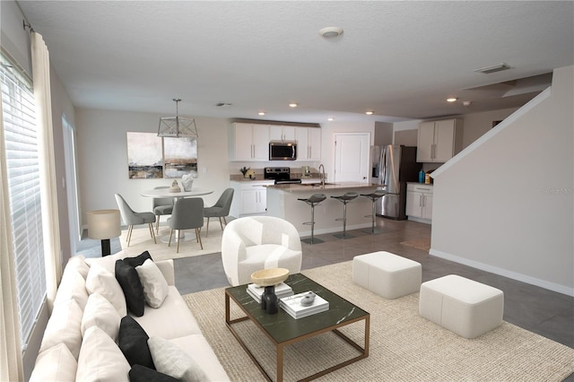 tiled living room with sink and a textured ceiling