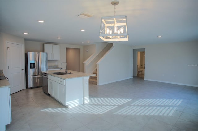 kitchen with white cabinets, sink, hanging light fixtures, light stone counters, and stainless steel appliances