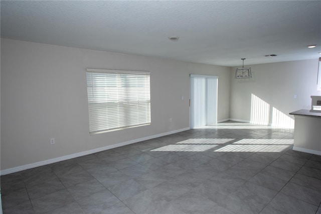 tiled empty room with a notable chandelier