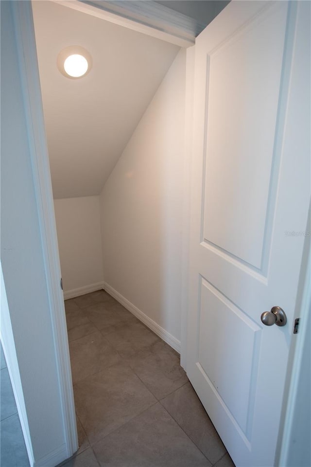 interior space featuring lofted ceiling and light tile patterned flooring