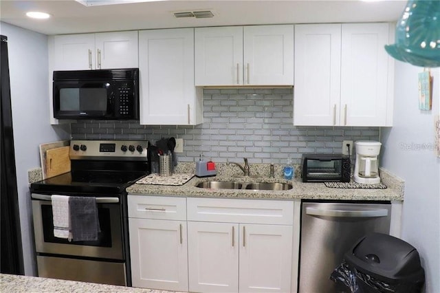 kitchen with white cabinetry, sink, tasteful backsplash, light stone counters, and appliances with stainless steel finishes