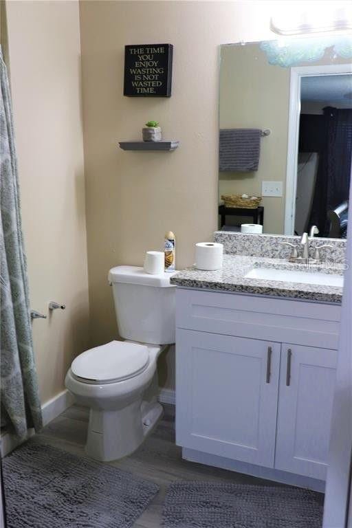 bathroom with hardwood / wood-style floors, vanity, and toilet