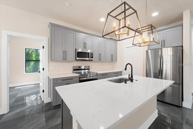 kitchen with a center island with sink, decorative light fixtures, light stone countertops, and appliances with stainless steel finishes