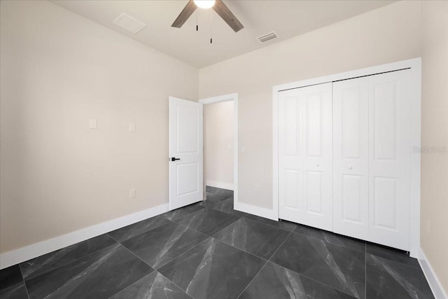 unfurnished bedroom with ceiling fan and a closet