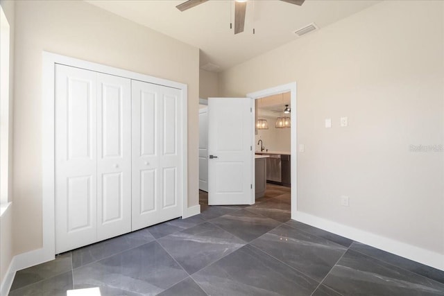 unfurnished bedroom featuring ceiling fan, sink, and a closet