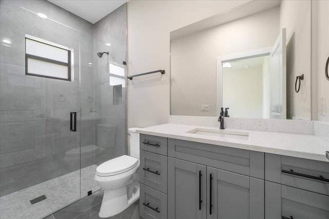 bathroom featuring tile patterned flooring, vanity, toilet, and walk in shower