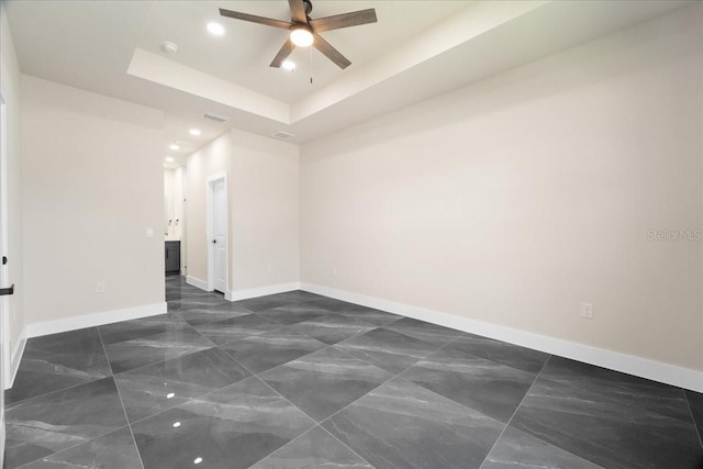 unfurnished room with a tray ceiling and ceiling fan