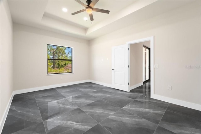 unfurnished room featuring a tray ceiling and ceiling fan