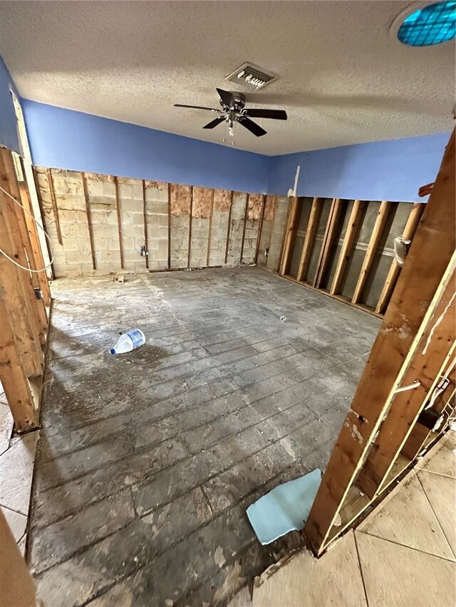 interior space with ceiling fan and a textured ceiling