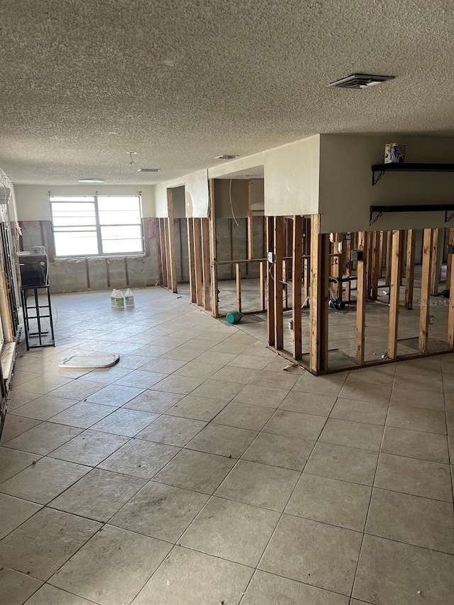 unfurnished room featuring tile patterned flooring and a textured ceiling