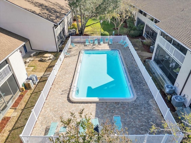 pool featuring ac unit, a patio area, fence, and central AC