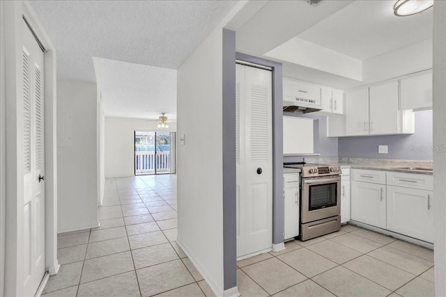 kitchen featuring light tile patterned floors, under cabinet range hood, white cabinets, light countertops, and stainless steel range with electric stovetop