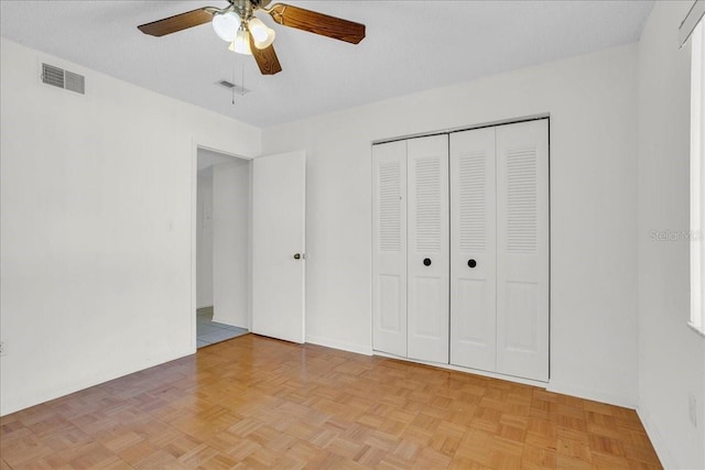 unfurnished bedroom featuring ceiling fan, a textured ceiling, visible vents, and a closet