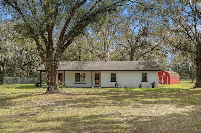 ranch-style home featuring an outbuilding and a front lawn