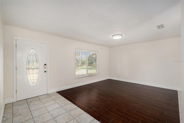 foyer entrance featuring a textured ceiling and light hardwood / wood-style floors