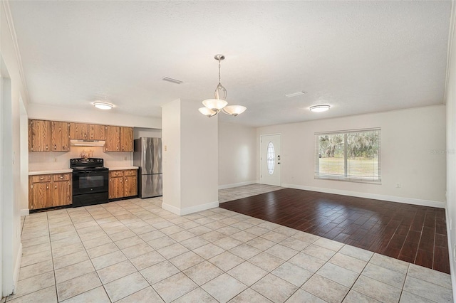 kitchen featuring stainless steel fridge, decorative light fixtures, light hardwood / wood-style floors, black / electric stove, and range hood