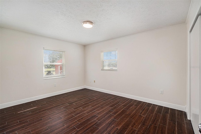 unfurnished room with a textured ceiling, dark wood-type flooring, and a wealth of natural light