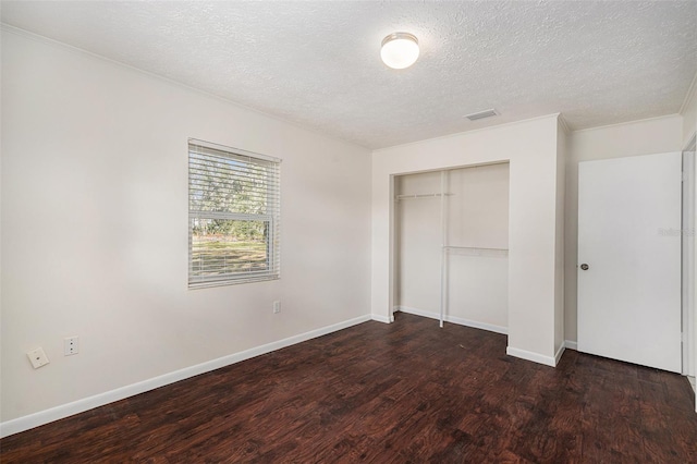 unfurnished bedroom with dark hardwood / wood-style floors, a textured ceiling, and a closet