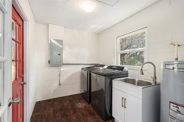 clothes washing area with water heater, dark hardwood / wood-style flooring, electric panel, a textured ceiling, and washer and clothes dryer