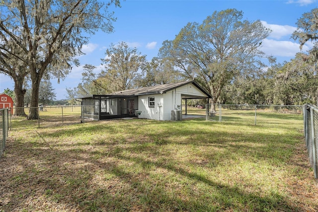 view of yard with a carport, a sunroom, and central air condition unit