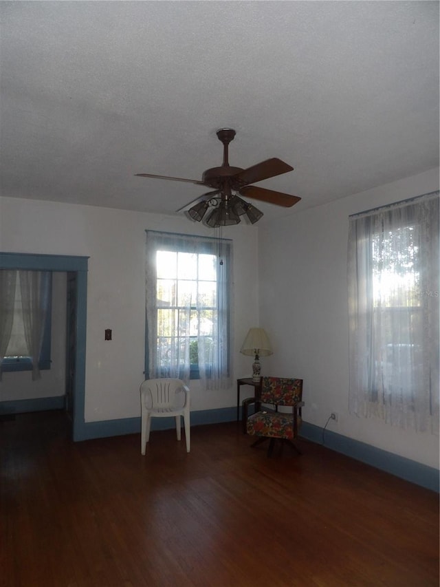 unfurnished room with a textured ceiling, dark hardwood / wood-style flooring, and ceiling fan