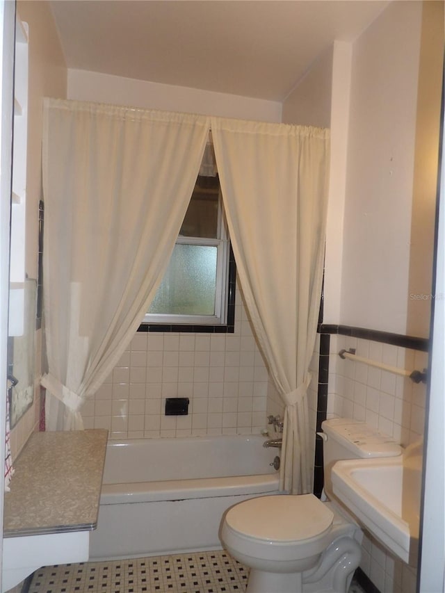 bathroom featuring tile patterned floors, toilet, tile walls, and shower / tub combo