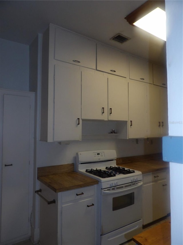 kitchen with white cabinetry, gas range gas stove, and butcher block countertops