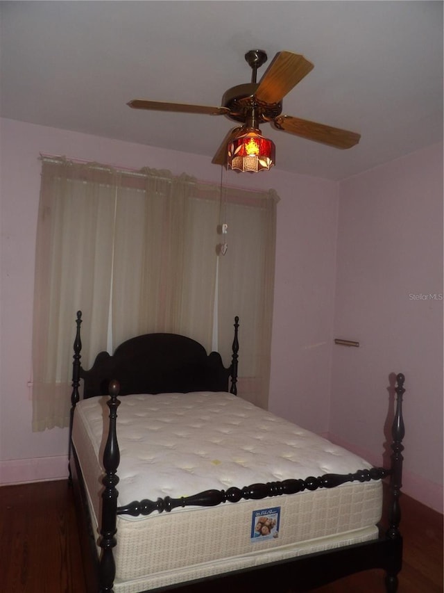 bedroom with ceiling fan and dark hardwood / wood-style flooring