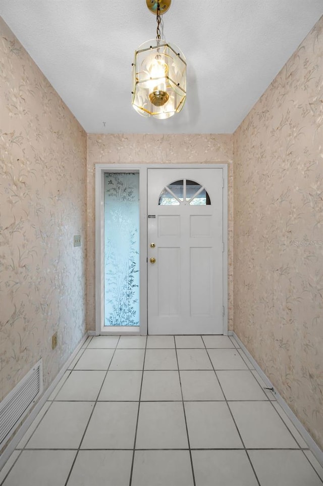 doorway featuring a textured ceiling and tile patterned floors