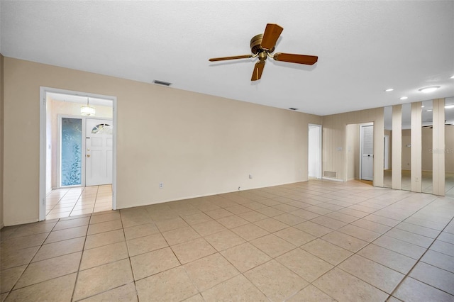 tiled spare room with ceiling fan