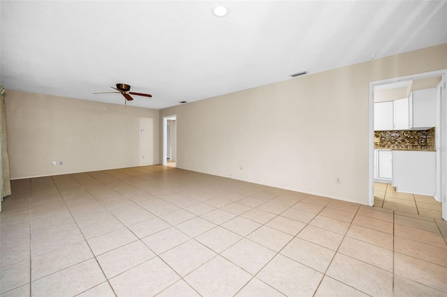 tiled spare room with ceiling fan