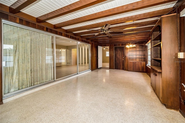 unfurnished room with beamed ceiling, ceiling fan, and wooden walls