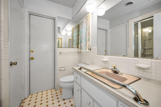 bathroom featuring vanity, an enclosed shower, and toilet