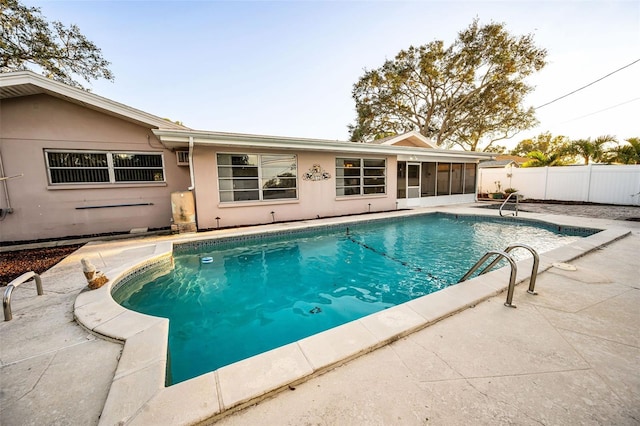 view of swimming pool with a patio and a sunroom