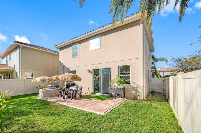 back of property featuring a lawn and a patio area