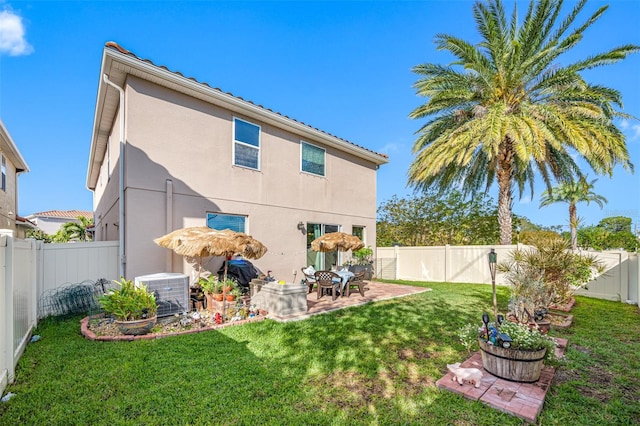 rear view of property with a patio, central air condition unit, and a lawn