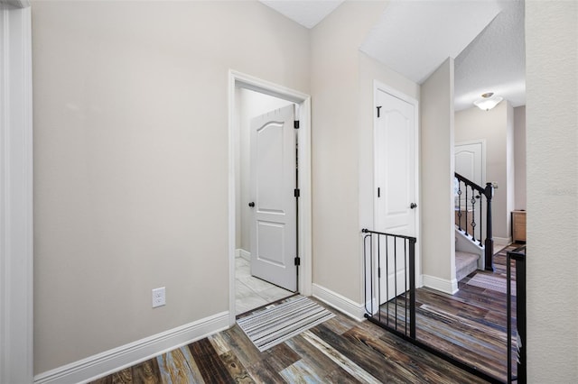 hallway with wood-type flooring and a textured ceiling