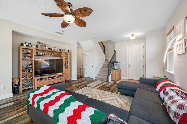 living room with a textured ceiling, dark hardwood / wood-style floors, and ceiling fan