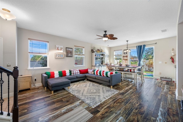 living room with a textured ceiling, dark hardwood / wood-style flooring, and ceiling fan