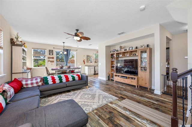 living room with dark hardwood / wood-style floors, ceiling fan, and a textured ceiling