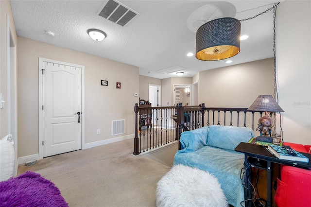 living area with light colored carpet and a textured ceiling