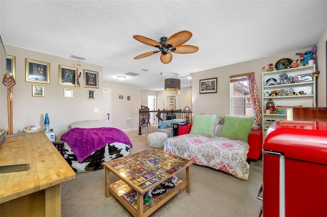 carpeted living room featuring a textured ceiling and ceiling fan