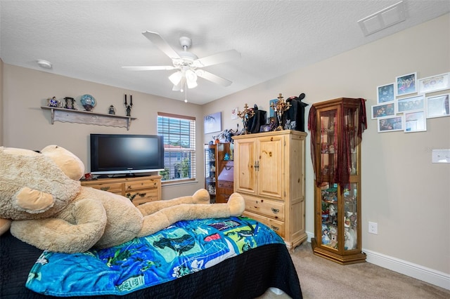 carpeted bedroom with a textured ceiling and ceiling fan