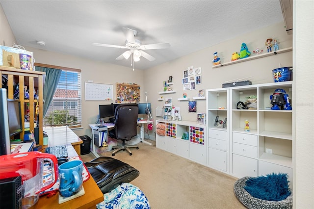 office space featuring a textured ceiling, light colored carpet, and ceiling fan