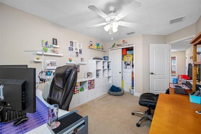 office featuring light carpet, a textured ceiling, and ceiling fan