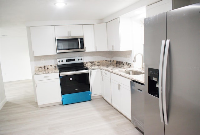 kitchen featuring white cabinets, light stone counters, sink, and stainless steel appliances