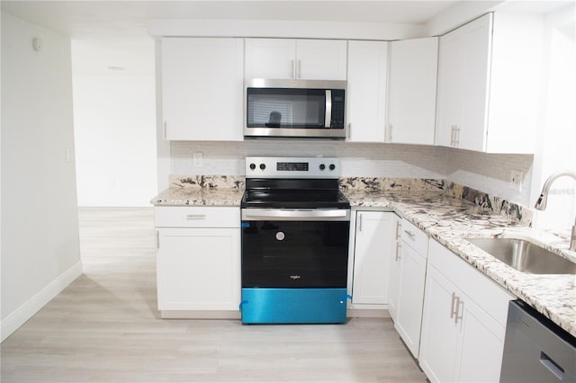 kitchen featuring light stone countertops, sink, white cabinetry, and stainless steel appliances