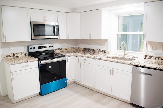 kitchen with white cabinetry, appliances with stainless steel finishes, and light hardwood / wood-style flooring