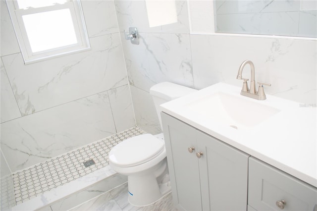 bathroom featuring vanity, toilet, and tiled shower