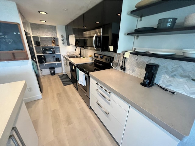 470 3rd St S Unit 405, Saint Petersburg, FL 33701 - kitchen featuring stainless steel appliances, open shelves, backsplash, white cabinetry, and light wood finished floors